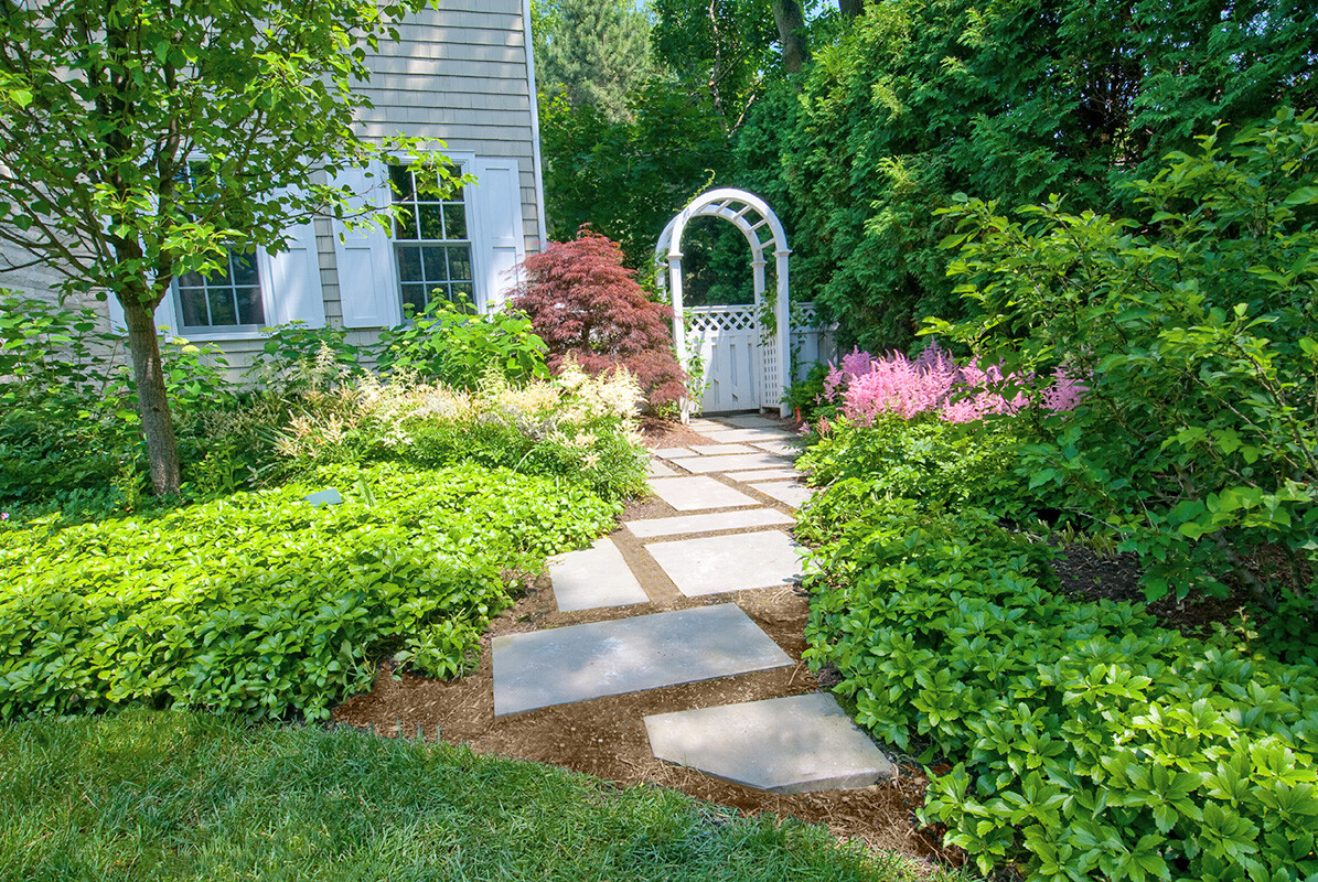 arbor in front yard with concrete steppers